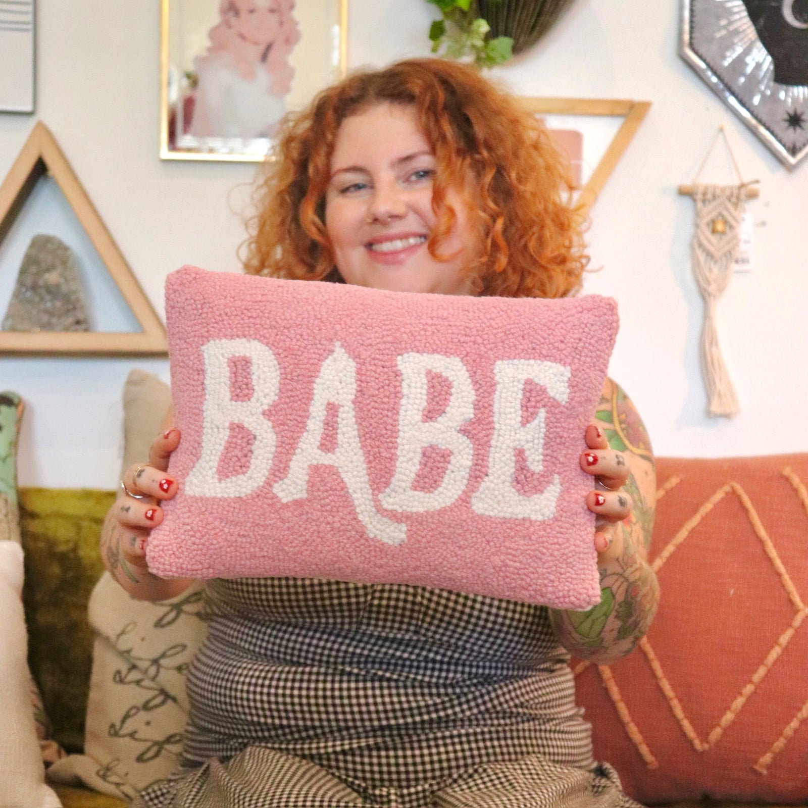 A woman holding the Babe Wool Hook Pillow.