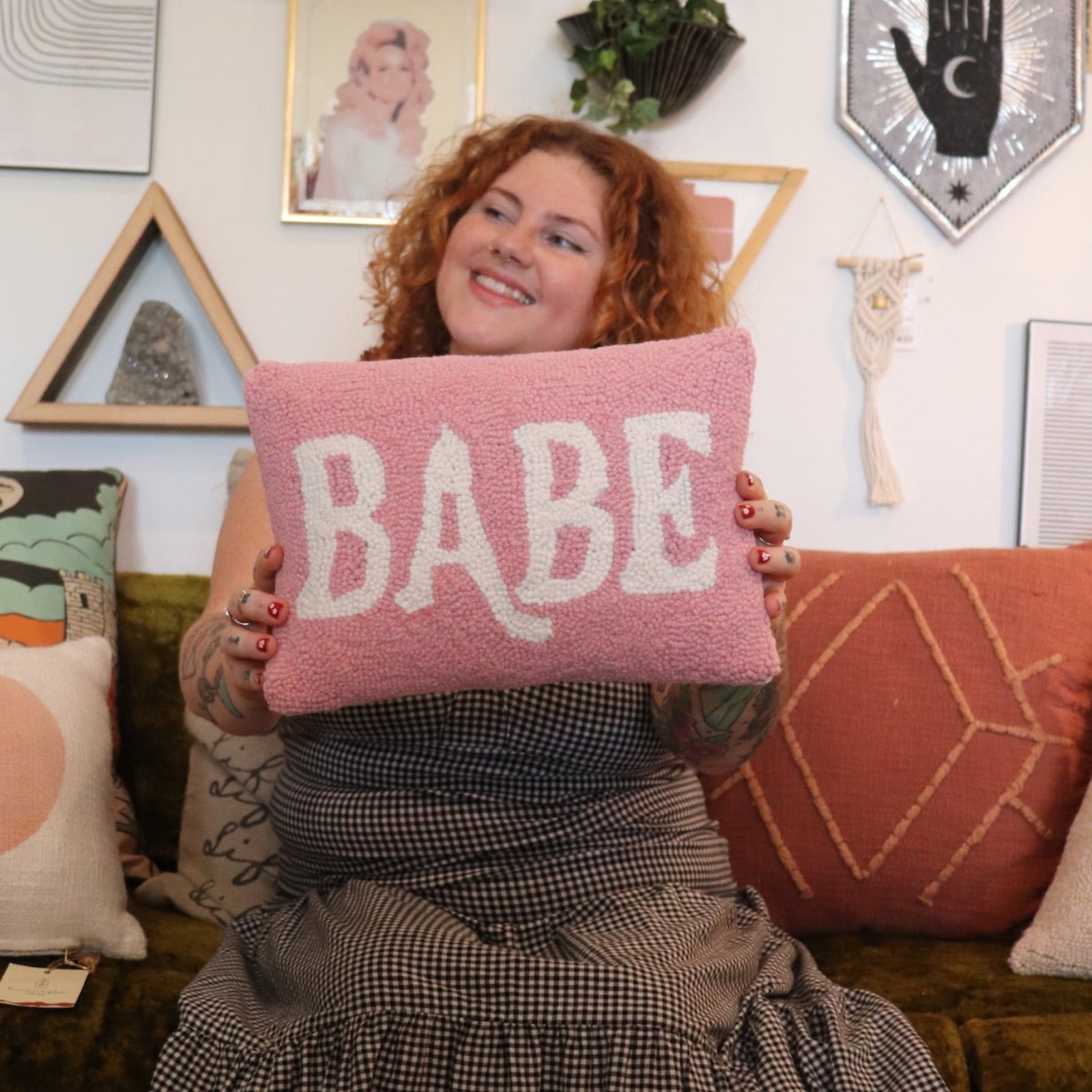 A woman holding the Babe Wool Hook Pillow.