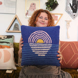 A woman holding the Blue Sunset Hook Pillow.