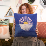 A woman holding the Blue Sunset Hook Pillow.