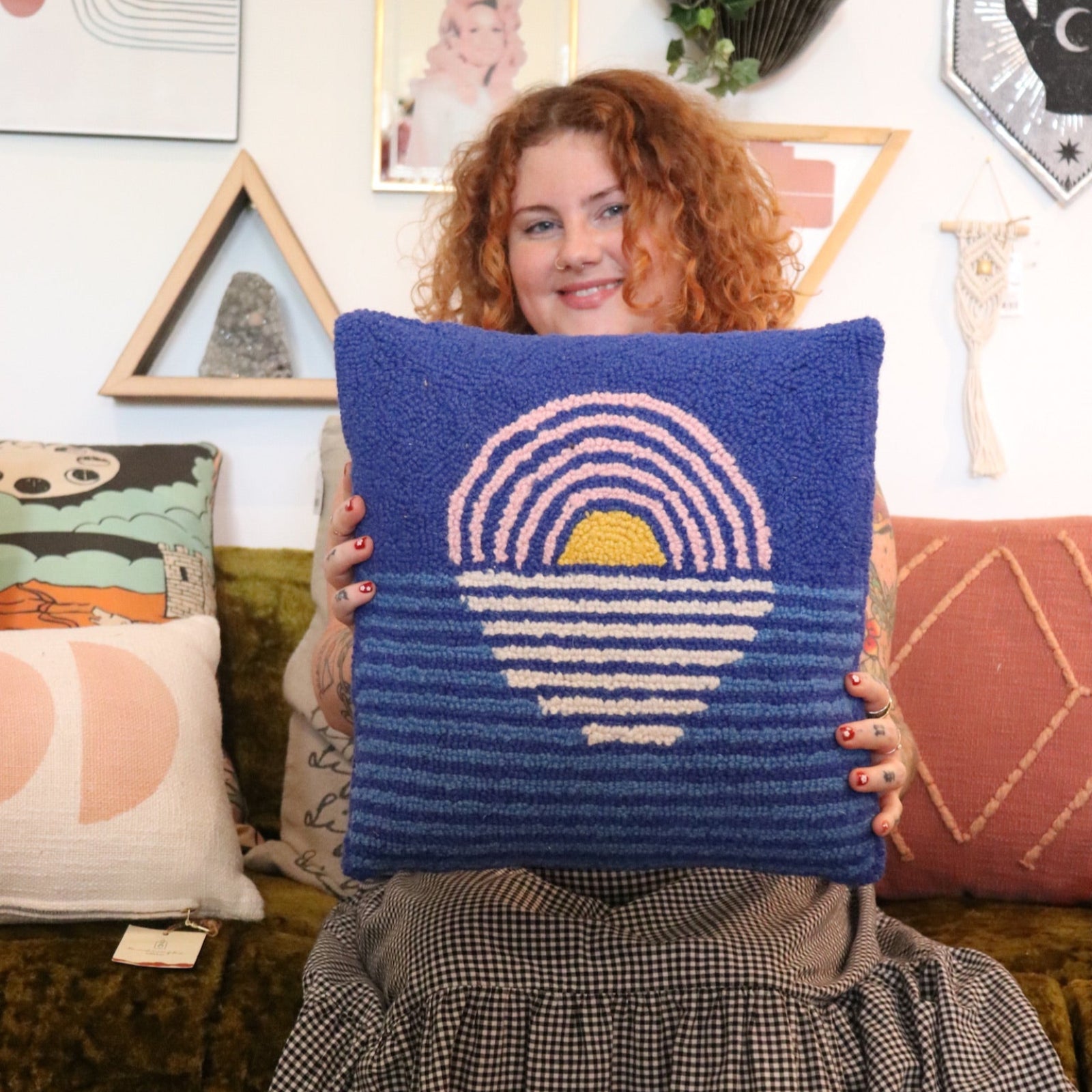 A woman holding the Blue Sunset Hook Pillow.