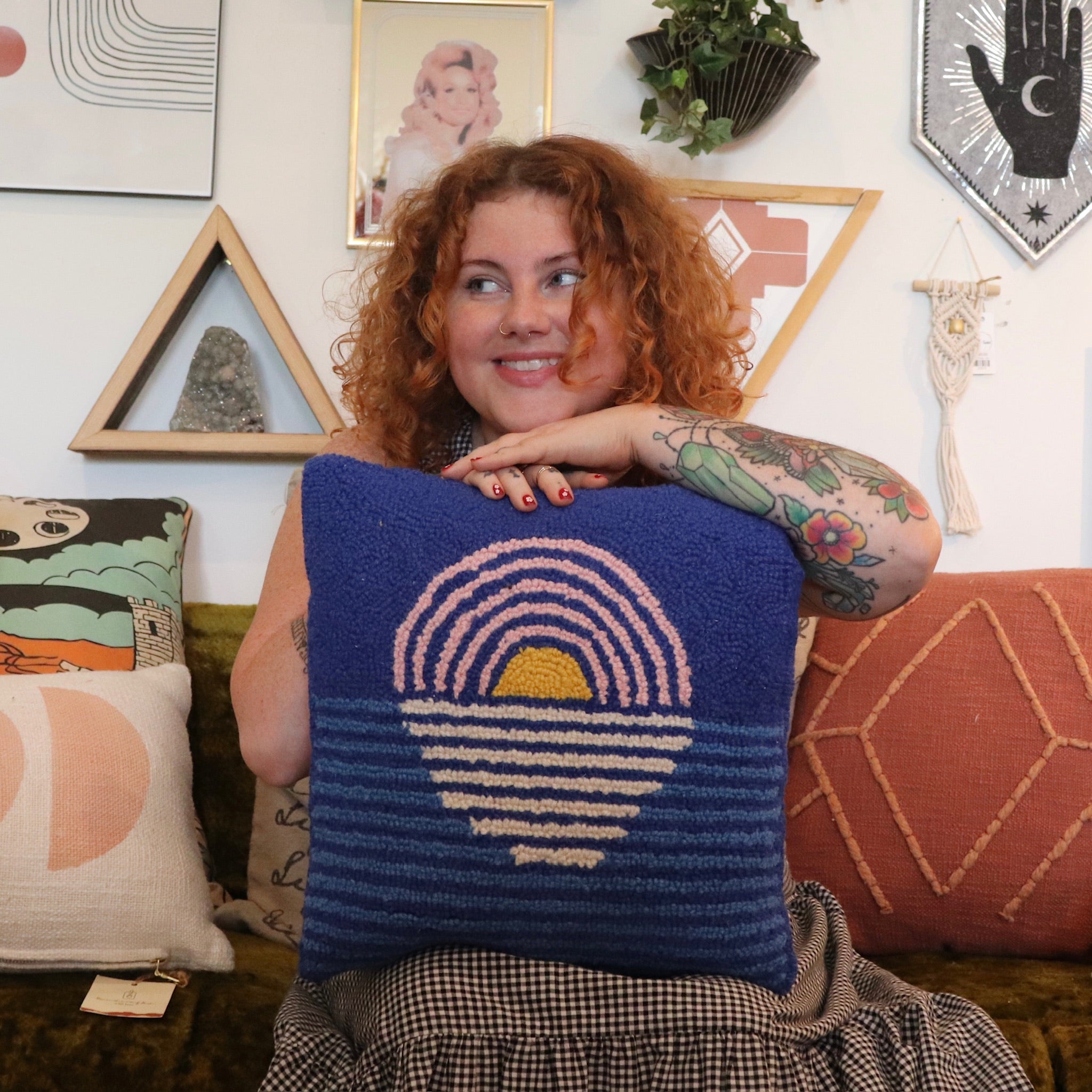 A woman holding the Blue Sunset Hook Pillow.