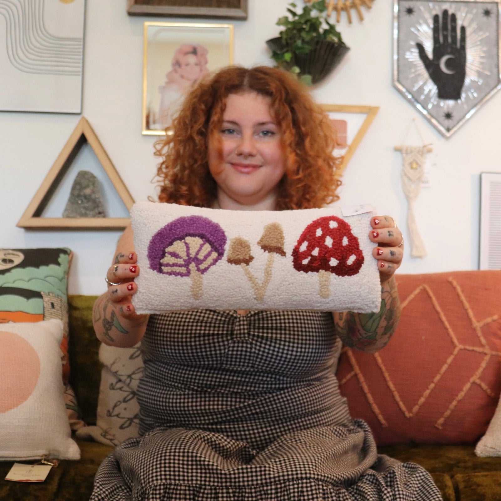 A woman holding the Mushrooms Wool Hook Pillow.