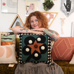 A woman holding theDiamonds & Pearls with Pom Poms Wool Hook Pillow.