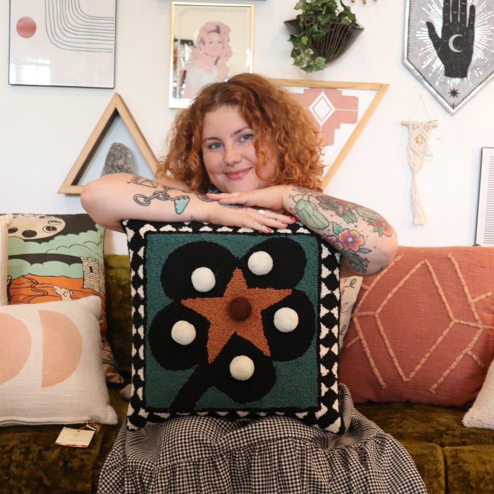 A woman holding theDiamonds & Pearls with Pom Poms Wool Hook Pillow.