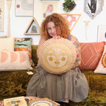 A woman holding the Ayo Sunshine Embroidered Decorative Pillow.