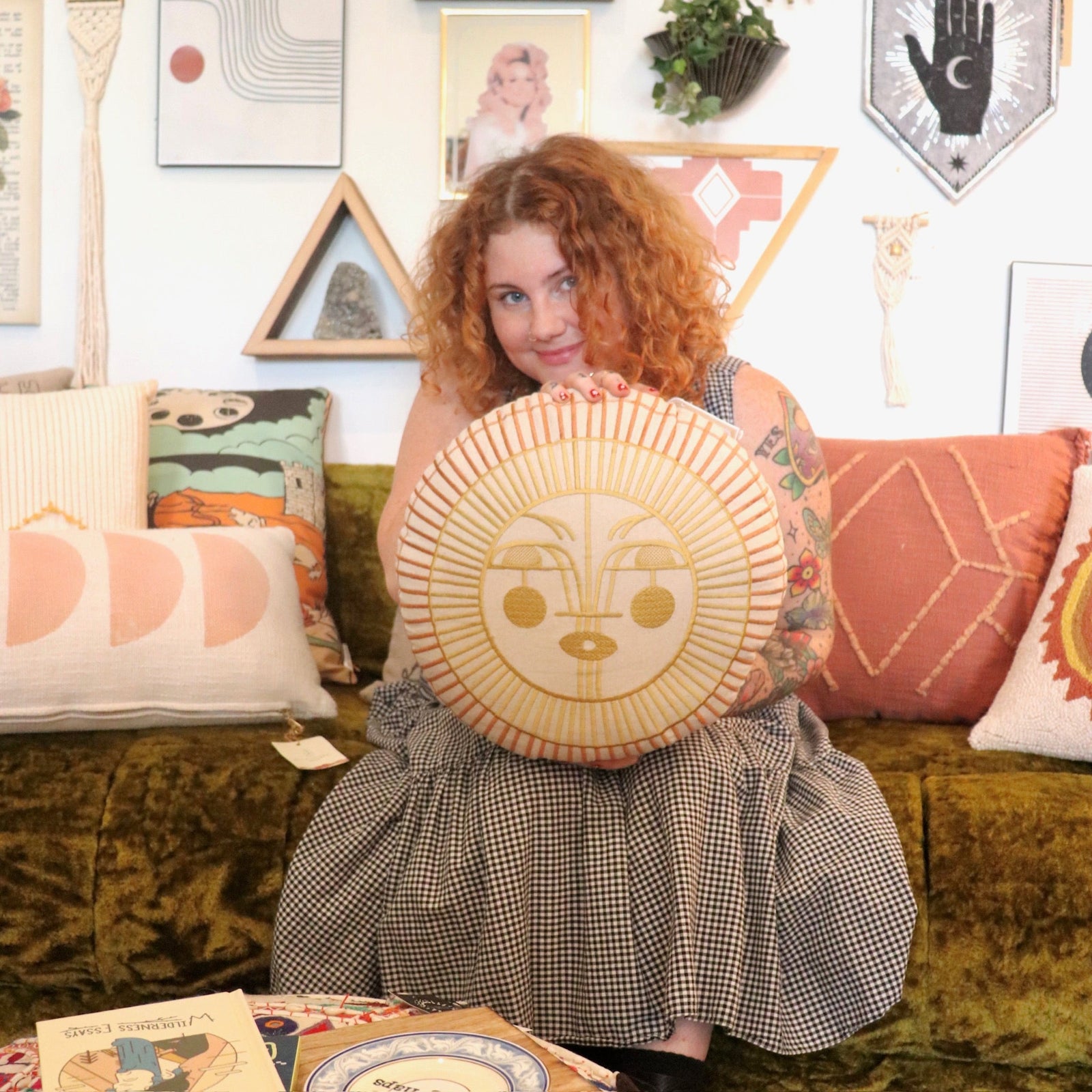 A woman holding the Ayo Sunshine Embroidered Decorative Pillow.