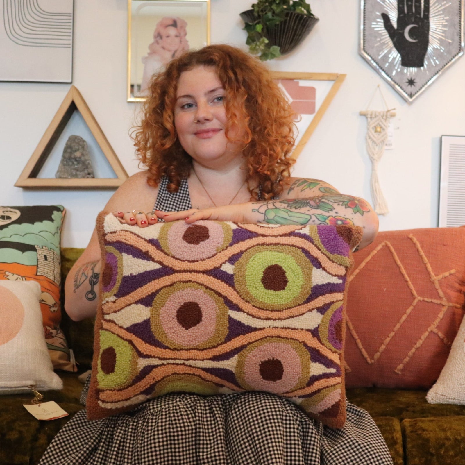 A woman holding the Snack Wool Hook Pillow.