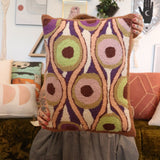 A woman holding the Snack Wool Hook Pillow.