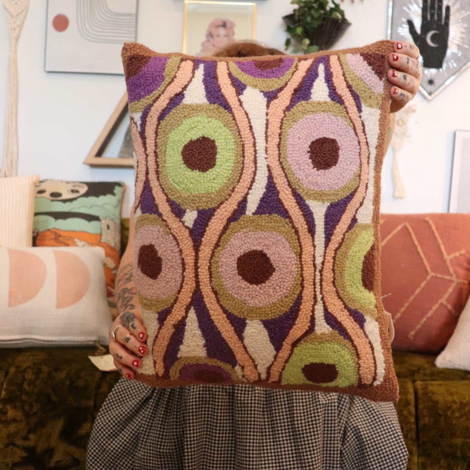 A woman holding the Snack Wool Hook Pillow.