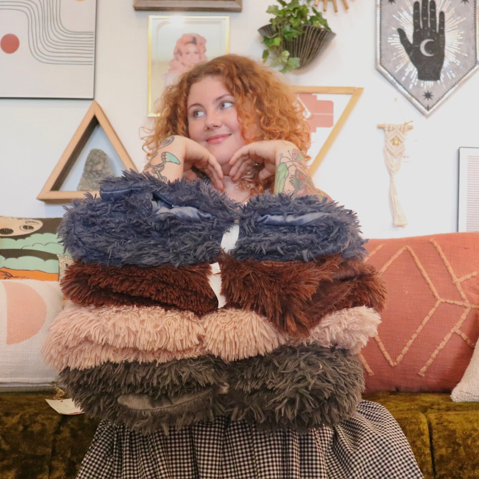 A woman holding all various colors of the Dreamy Faux Fur Throw Blanket.