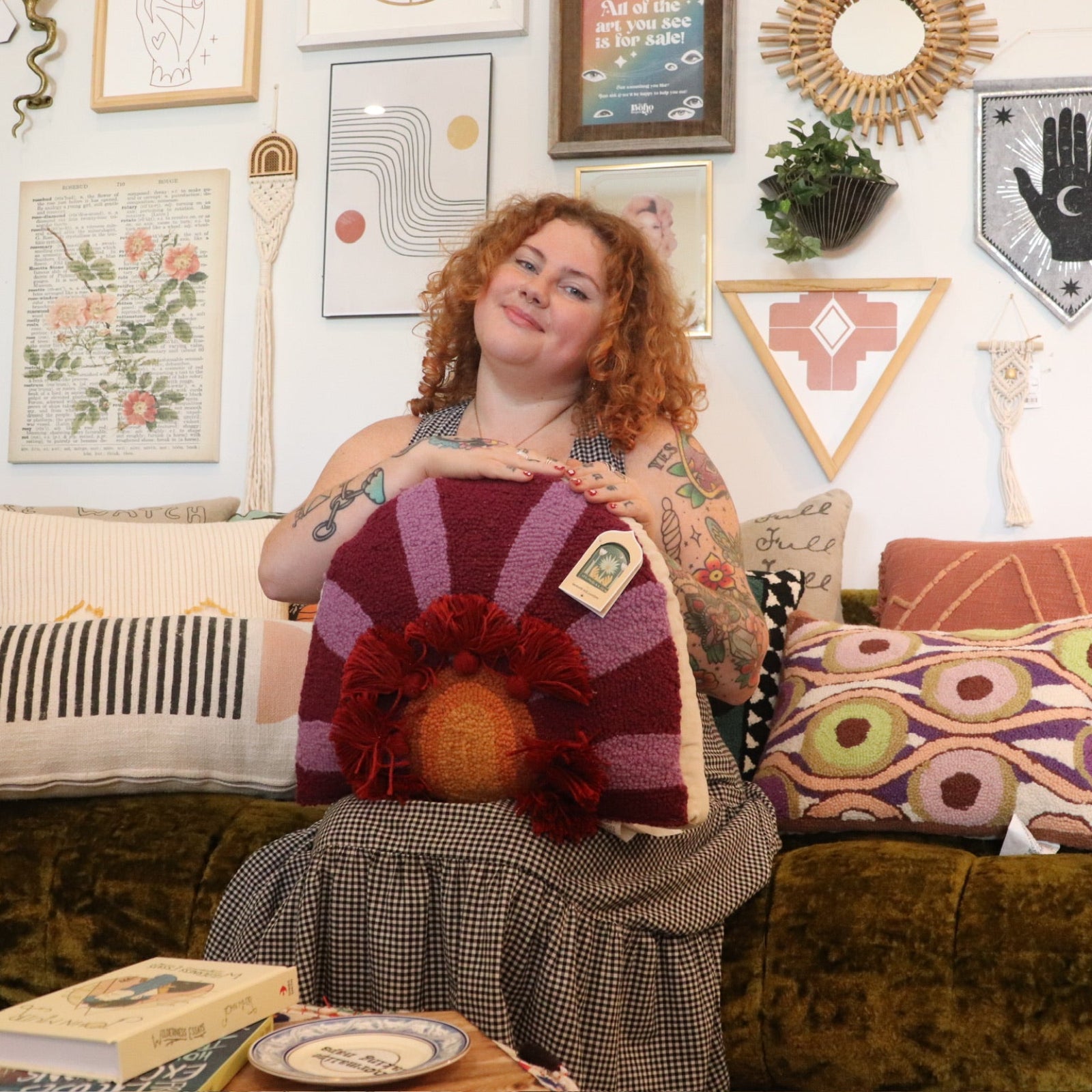 A woman holding the 'In Bloom' Wool Hook Pillow with Tassels.