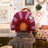 A woman holding the 'In Bloom' Wool Hook Pillow with Tassels.