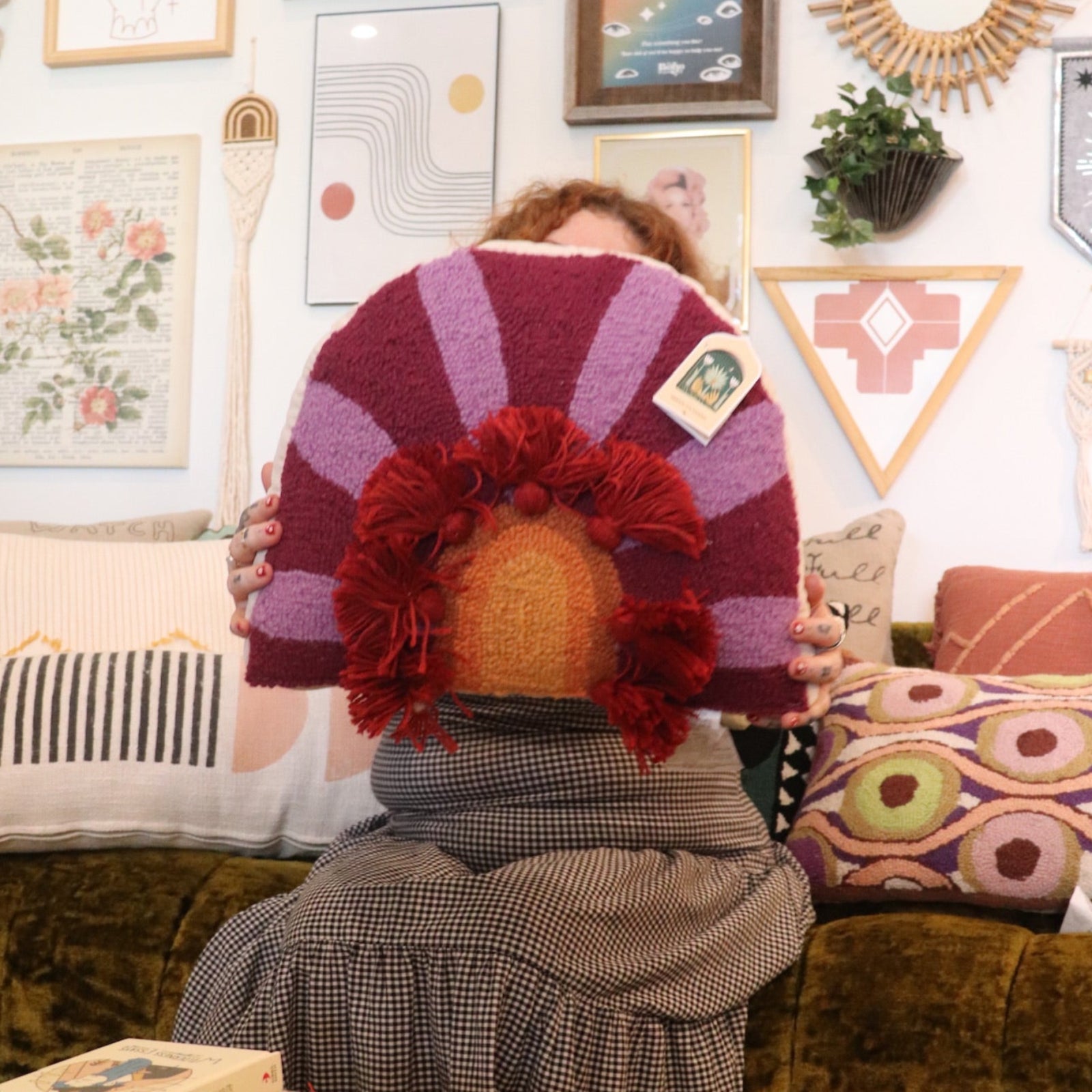 A woman holding the 'In Bloom' Wool Hook Pillow with Tassels.