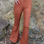 Someone wearing the Pecan Suede Bell Bottoms with an orange, red, and brown top.