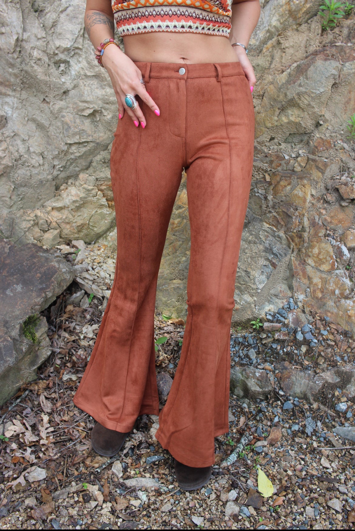 Someone wearing the Pecan Suede Bell Bottoms with an orange, red, and brown top.