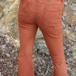Someone wearing the Pecan Suede Bell Bottoms with an orange, red, and brown top.
