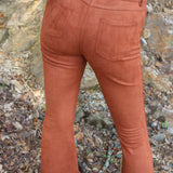 Someone wearing the Pecan Suede Bell Bottoms with an orange, red, and brown top.