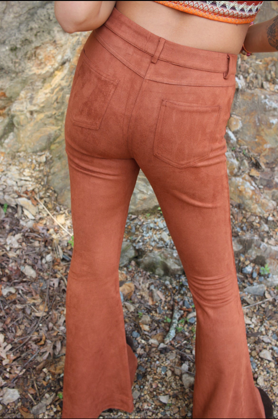 Someone wearing the Pecan Suede Bell Bottoms with an orange, red, and brown top.