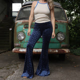 A woman wearing the Navy Velvet Bell Bottom Pants with a cream colored tank all in front of a vintage Volkswagen bus.