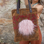 A woman holding the Geometric Velvet Tapestry Tote with Pink Faux Fur.