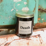 The Death candle in front of a white and teal rusty background.