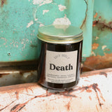 The Death candle in front of a white and teal rusty background.