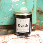 The Death candle in front of a white and teal rusty background.