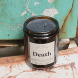 The Death candle in front of a white and teal rusty background.