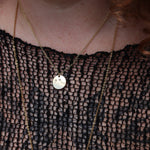 Someone wearing the Aries 14k Gold Dipped Nickel-Free Zodiac Necklace with a black net top.