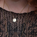 Someone wearing the Aries 14k Gold Dipped Nickel-Free Zodiac Necklace with a black net top.