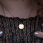 Someone wearing the Leo 14k Gold Dipped Nickel-Free Zodiac Necklace with a black net top.