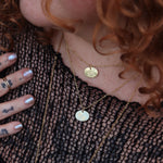 A woman wearing two of the 14k Gold Dipped Nickel-Free Birth Month Flower Necklaces with a black mesh top.