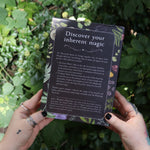 Someone holding the Witchcraft Boxed Set by Arin Murphy-Hiscock in front of greenery showing the back.