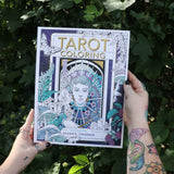 Someone holding the Tarot Coloring - Coloring Book in front of greenery.