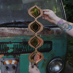 Someone holding the Retro Tear Drop Acrylic Mirror in front of a rusted vintage Volkswagen bus.