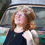 A woman wearing the beige Hand-Embroidered Floral Soft Beret Stylish Hat with a black shirt.