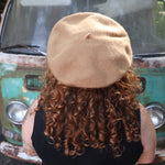 A woman wearing the beige Hand-Embroidered Floral Soft Beret Stylish Hat with a black shirt, showing off the back of the hat.