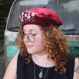 A woman wearing the red Hand-Embroidered Floral Soft Beret Stylish Hat with a black tank.
