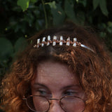 A red headed women wearing the Bridal Tiara - Rose Gold Hematite & Freshwater Pearl in front of greenery.