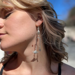 A woman wearing the Silver Magic Mobile 3 inch. Earrings.