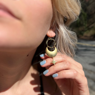 A woman wearing the Brass Star Dancer 2 inch. Earrings.