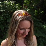 A woman wearing the Fairy Crown / Celtic Tiara - Amber: Gold in front of greenery.