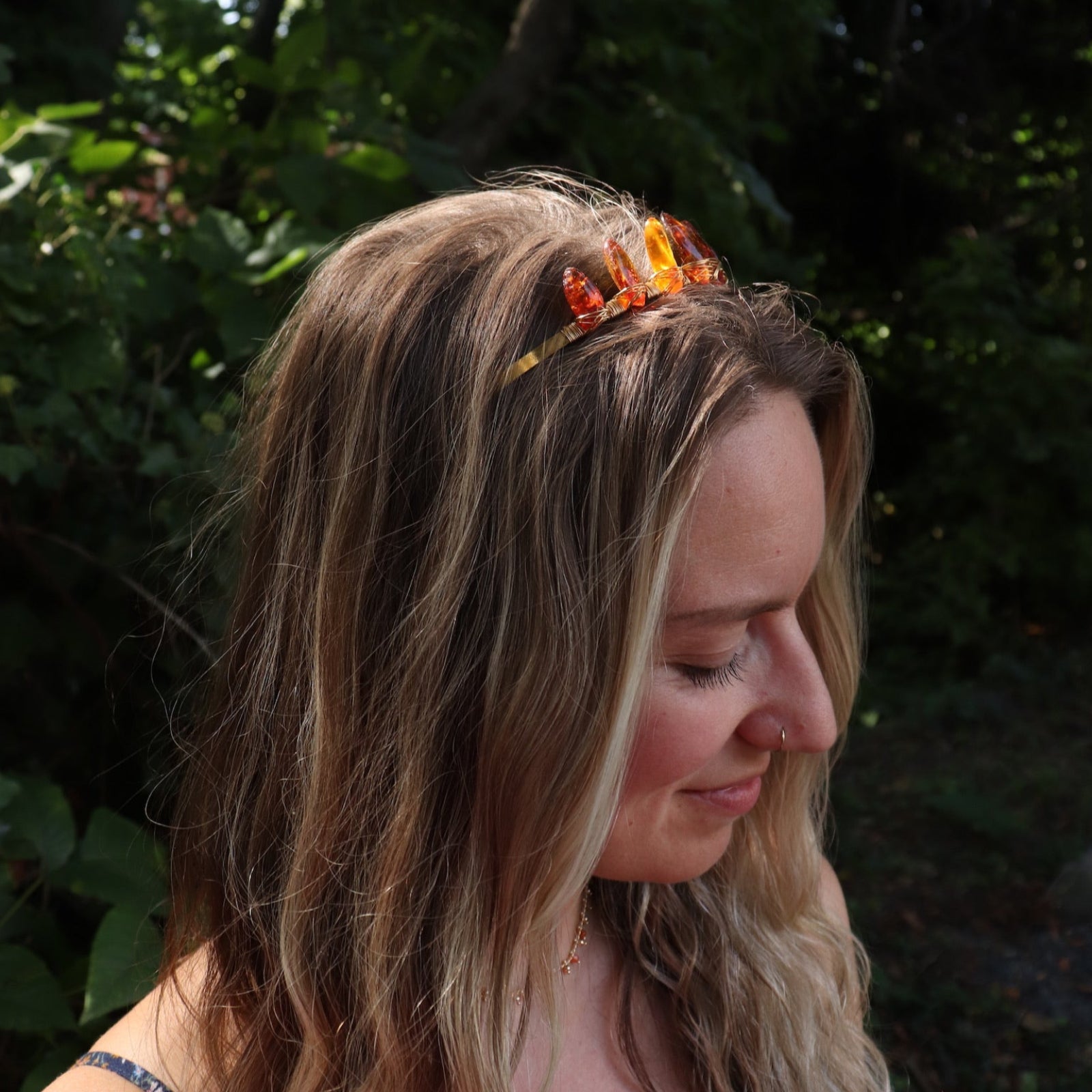 A woman wearing the Fairy Crown / Celtic Tiara - Amber: Gold in front of greenery.