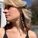 A woman wearing the Realm Earrings with a black dress.