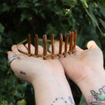 Someone holding the Fairy Crown / Celtic Tiara - Gold Coral in front of greenery.