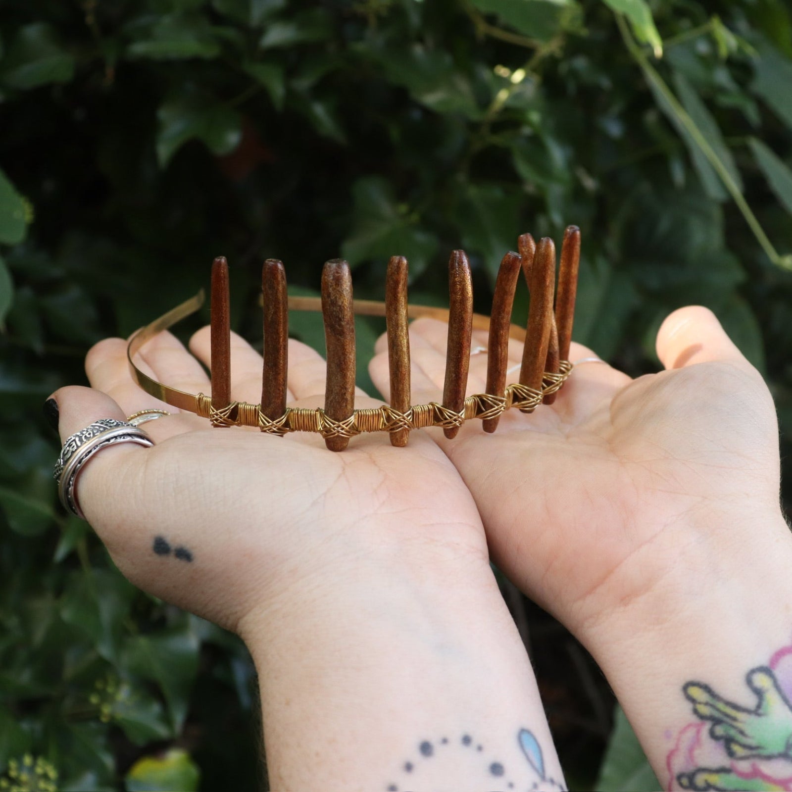 Someone holding the Fairy Crown / Celtic Tiara - Gold Coral in front of greenery.