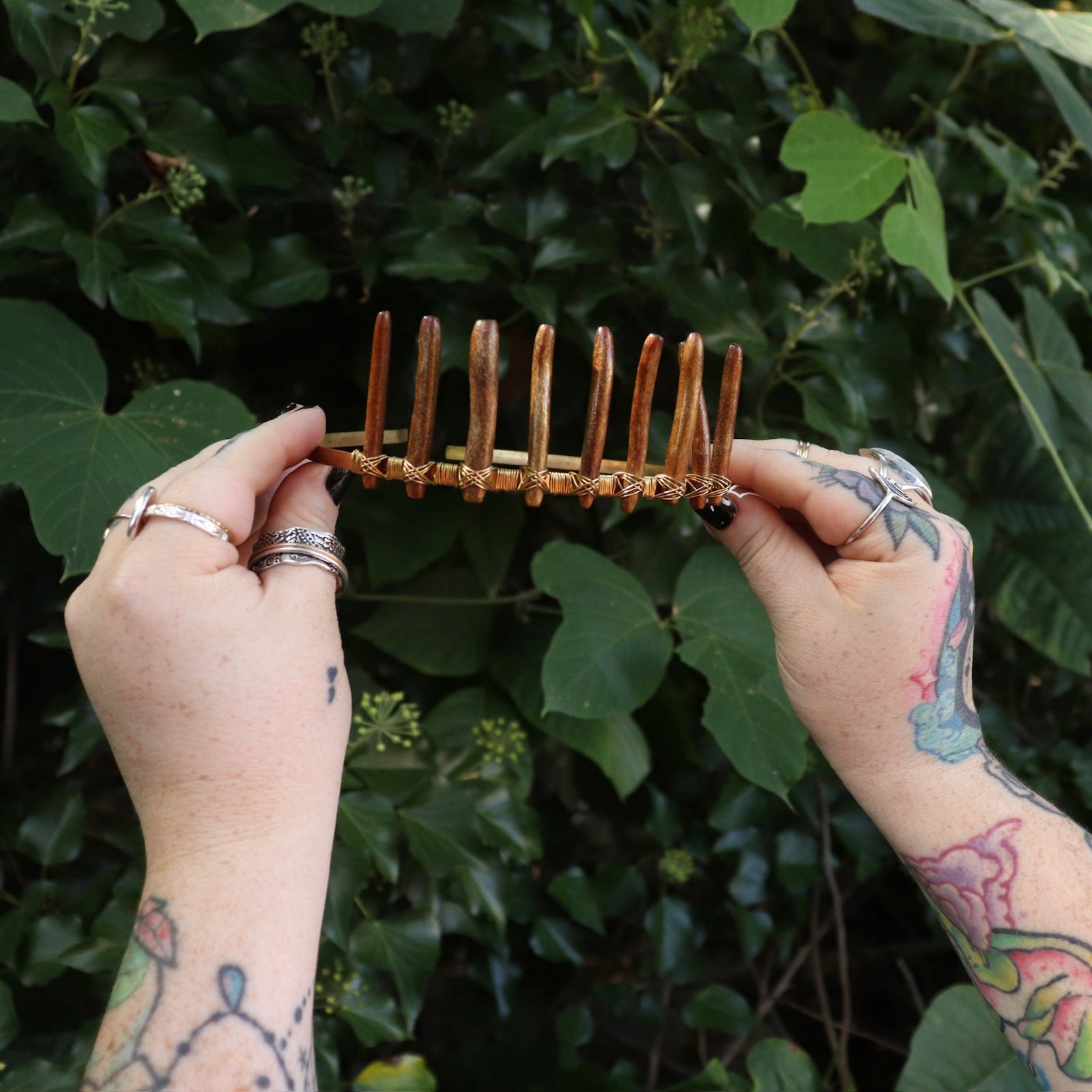 Someone holding the Fairy Crown / Celtic Tiara - Gold Coral in front of greenery.