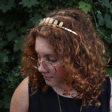 A woman wearing the Fairy Crown / Celtic Tiara - Peruvian Yellow Opal in front of greenery.