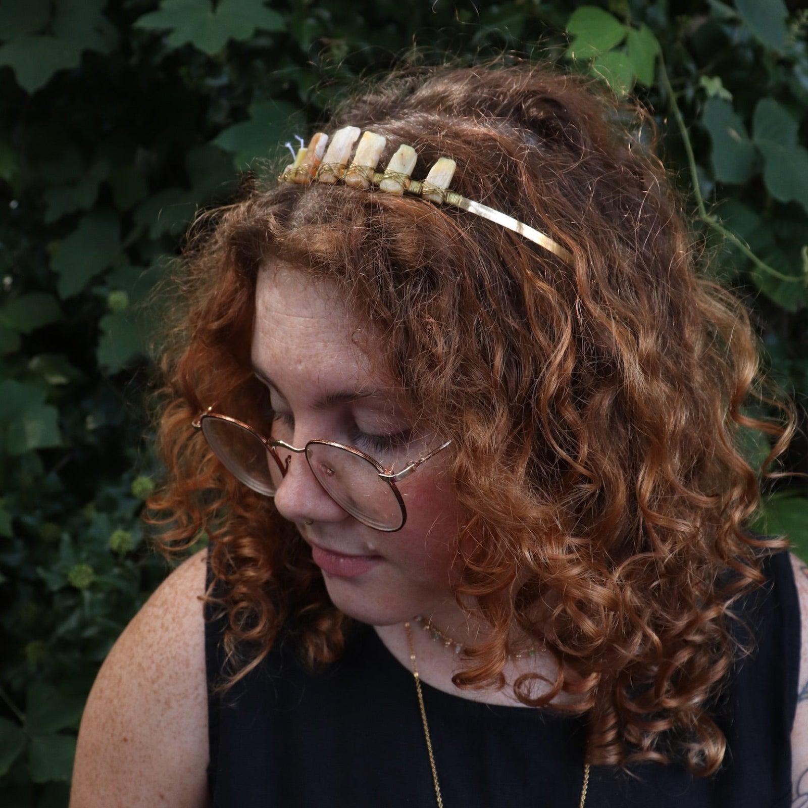 A woman wearing the Fairy Crown / Celtic Tiara - Peruvian Yellow Opal in front of greenery.